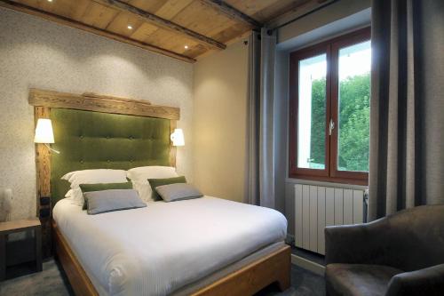 A bed or beds in a room at Hôtel du Crêt Rond