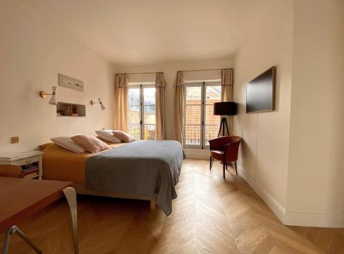 a bedroom with a bed and a desk and window at Grande maison hyper centre Versailles in Versailles