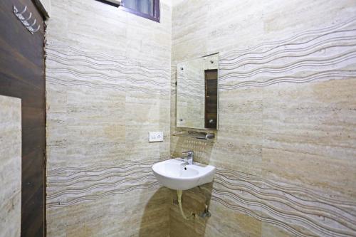 a bathroom with a sink and a mirror on the wall at Kiara-By Aashiyana Group Near Delhi Airport in New Delhi