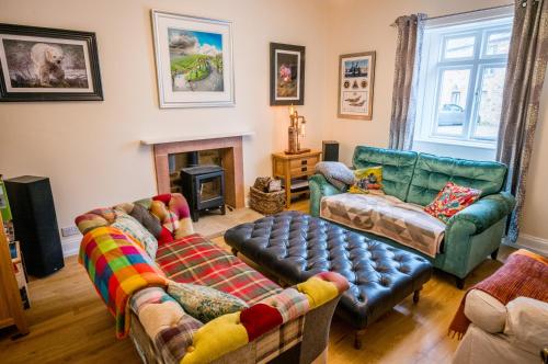 a living room with couches and a fireplace at Abbey Farmhouse 