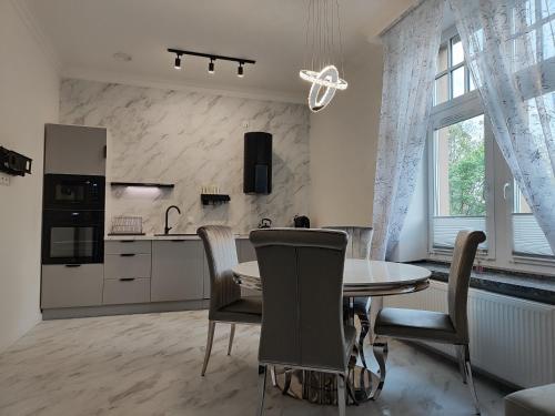 a kitchen and dining room with a table and chairs at Apartament Jak w banku in Kłodzko
