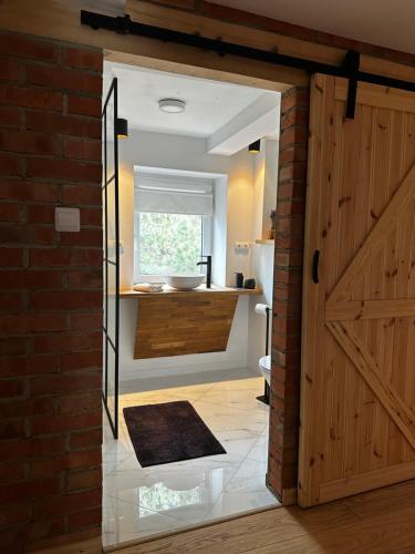 Łazienka z drzwiami stodoły i umywalką w obiekcie Dom Cukiernika w mieście Lwówek Śląski