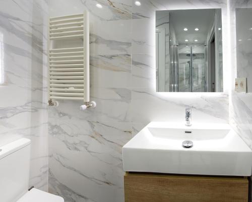 een witte badkamer met een wastafel en een spiegel bij Encantador Apartamento con Wifi en Sestao in Sestao