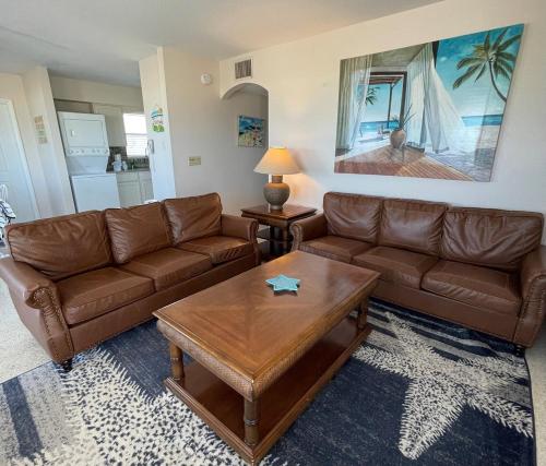 a living room with brown leather couches and a coffee table at 763 North Shore Downstairs Apts in Anna Maria