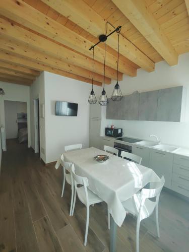 a kitchen with a white table and white chairs at Parsifal House in Chioggia