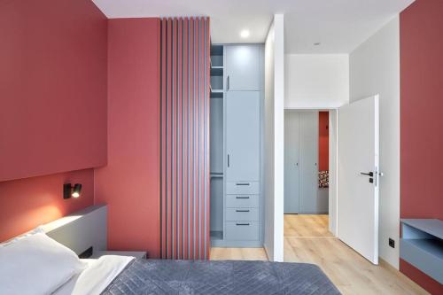 a bedroom with red walls and a bed and a closet at Sea Moreto Apartment 2 in Burgas City