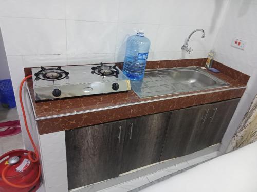 uma cozinha com um fogão e um lavatório com uma garrafa de água em Hym em Mombasa