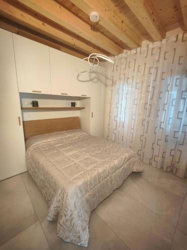 a bedroom with a bed in a room with wooden ceilings at Parsifal House in Chioggia