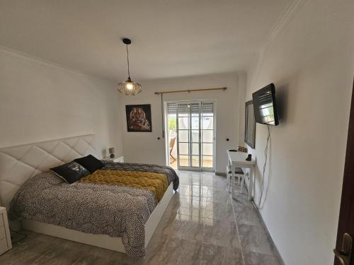 a bedroom with a bed and a television on a wall at Oceanic Opulence Delux Apartment in Monte Gordo