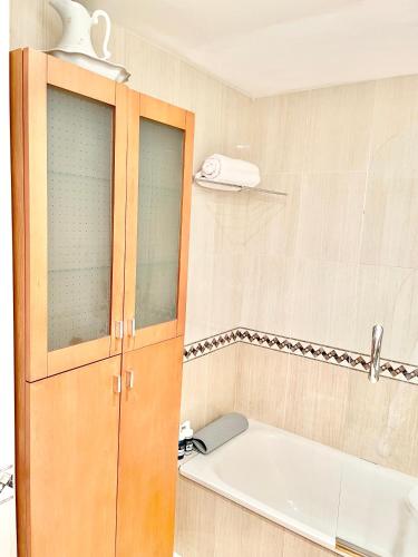 a bathroom with a bath tub and a sink at Apartamento San Juan. Piscina y Parking privado. in San Juan de la Arena