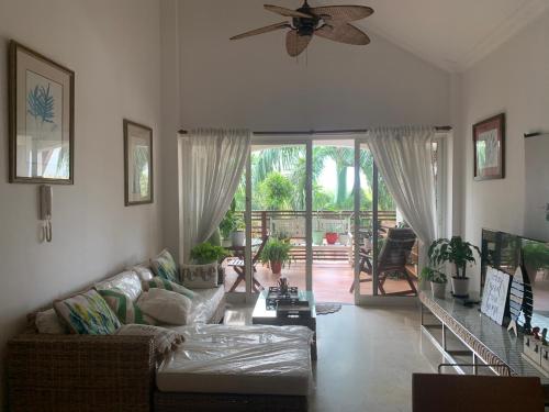ein Wohnzimmer mit einem Sofa und einem Deckenventilator in der Unterkunft Habitación privada en apartamento in Punta Cana