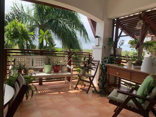einen Balkon mit einem Tisch, Stühlen und Pflanzen in der Unterkunft Habitación privada en apartamento in Punta Cana