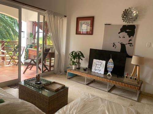ein Wohnzimmer mit einem Sofa und einem Tisch in der Unterkunft Habitación privada en apartamento in Punta Cana