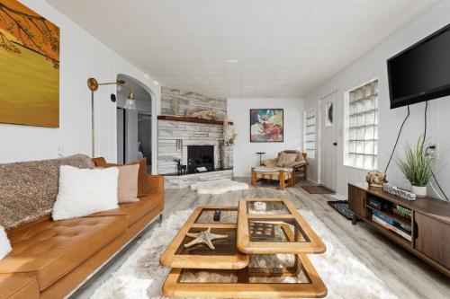 a living room with a couch and a table at Elk Rapids Bungalow Garden Firepit AC in Elk Rapids