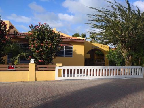 a yellow house with a white fence in front of it at 30 Kas Di Mi Sonjo in Kralendijk