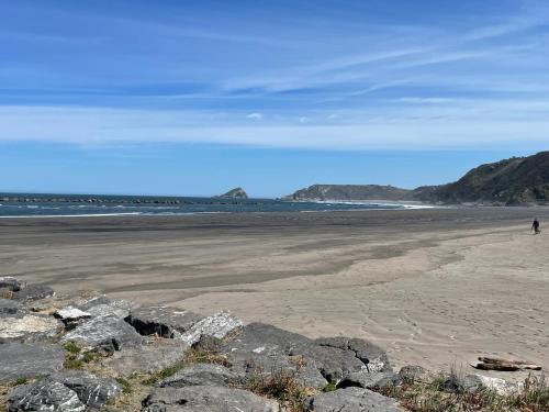 a beach with a person walking on the sand at Apartamento San Juan. Piscina y Parking privado. in San Juan de la Arena