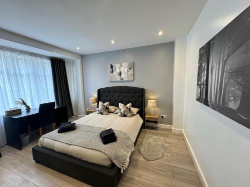 a bedroom with a bed and a desk in it at Elegant Large Room in Beckenham