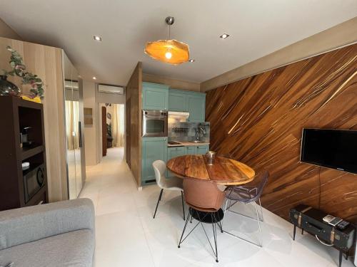 Il comprend une cuisine et une salle à manger avec un mur en bois. dans l'établissement Appartement sur la Pinède à Juan les pins, à Antibes