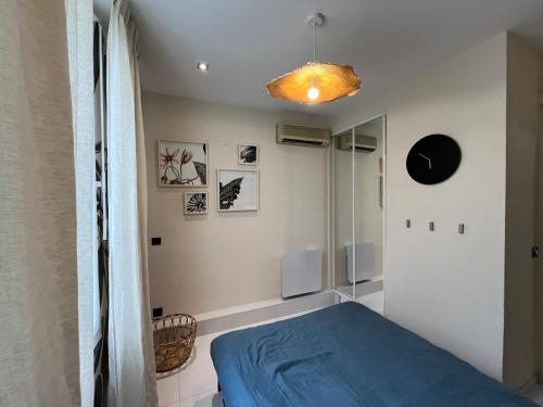 - une chambre avec un lit bleu dans l'établissement Appartement sur la Pinède à Juan les pins, à Antibes