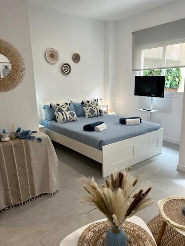 1 dormitorio con 1 cama y TV. en Estudio coqueto con Terraza, en Alicante