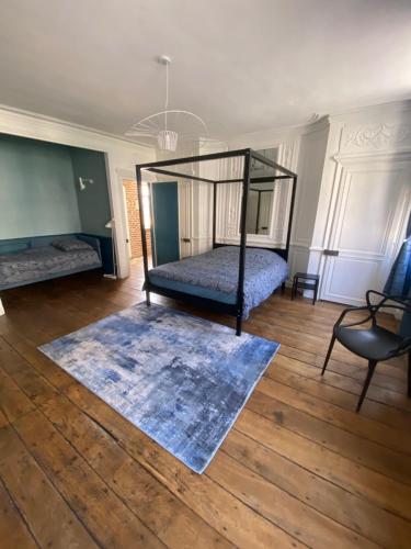 a bedroom with a bed and a rug on a wooden floor at Chez Victor H in Amiens