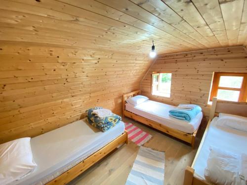 a room with two beds in a log cabin at Rupa Guest House in Theth