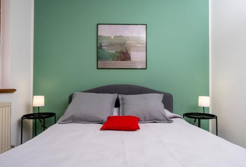 a bedroom with a white bed with a red pillow at Le Mandarine Apartments - Superior Apartment in Udine