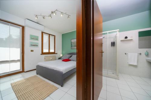 a bedroom with a bed and a walk in shower at Le Mandarine Apartments - Superior Apartment in Udine