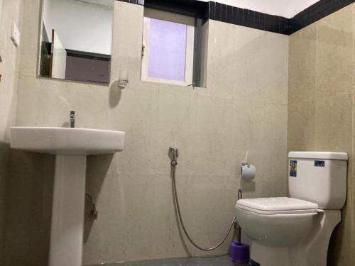 a bathroom with a toilet and a sink and a window at Goroomgo Maujis Villa Guest House Prayagraj Near Sangam Railway Station - Luxury Room Quality - Excellent Customer Service in Prayagraj
