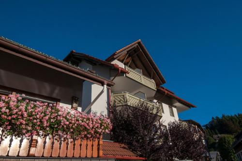 a house with pink flowers on a fence at Apartment 04 - Ferienresidenz Roseneck, mit Schwimmbad in Todtnauberg bei Feldberg in Todtnauberg