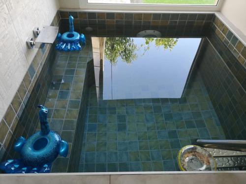 ducha con 2 jarrones azules en el suelo de baldosa en La Mediterranea, en Palafolls
