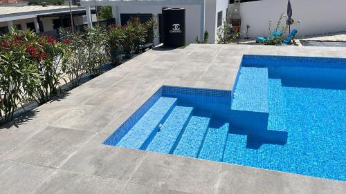 a blue swimming pool next to a house at Quinta Ria Formosa in Olhão