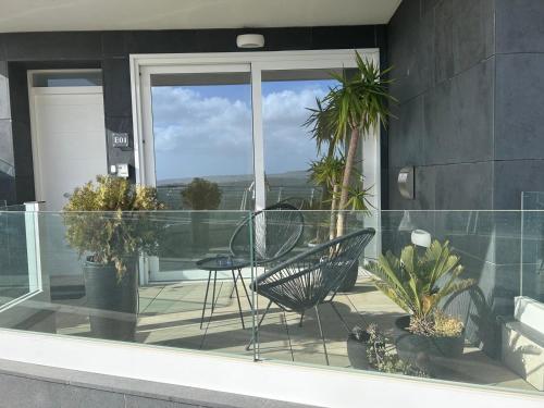 einen Balkon mit einem Tisch, Stühlen und Pflanzen in der Unterkunft Spacious Luxury 3 bedroom apartment - Southridge - Mellieha in Mellieħa