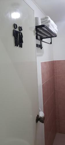 uma casa de banho com um chuveiro e uma porta com uma toalha em Caryolba hometel em Calapan