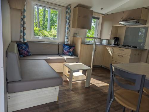 a small living room with a couch and a table at Mobil Home Confort 4 Places in Biesheim