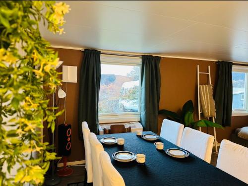 une salle à manger avec une table bleue et des chaises blanches dans l'établissement Aurora dream, à Skjervøy