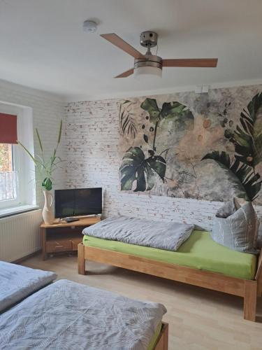a bedroom with two beds and a ceiling fan at Ferienwohnung "Sonnenschein" 75 qm mit großem Garten im lausitzer Seenland in Drochow