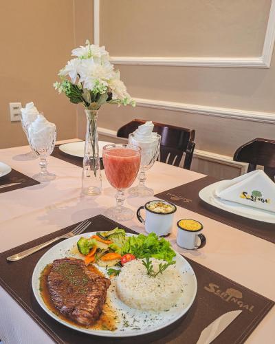 a table with a plate of food on a table at Seringal Hotel in Manaus