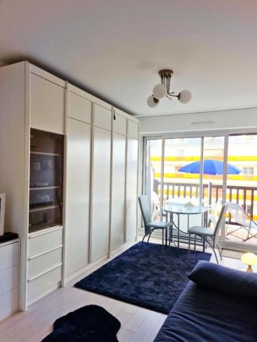 un salon avec une table et une salle à manger dans l'établissement Charmant studio dans résidence front de mer, à Cabourg