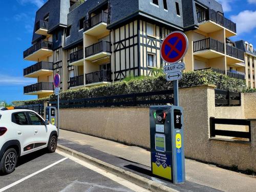 a white car parked on a street with a parking meter at Charmant studio dans résidence front de mer in Cabourg