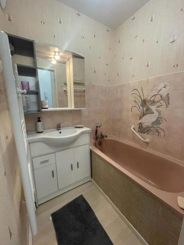 La salle de bains est pourvue d'un lavabo, d'une baignoire et d'un porte-parole. dans l'établissement Charmant studio dans résidence front de mer, à Cabourg