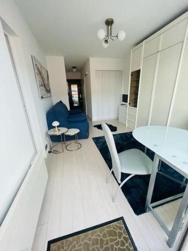 - un salon avec une table et une chaise bleue dans l'établissement Charmant studio dans résidence front de mer, à Cabourg
