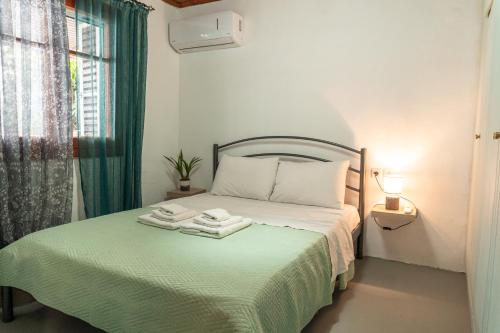 een slaapkamer met een bed met twee handdoeken erop bij Christine's House in Nafpaktos