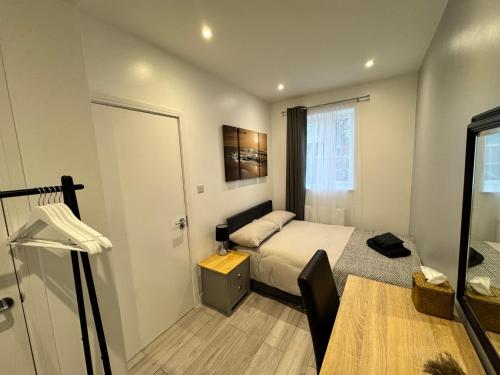 een kleine slaapkamer met een bed en een deur bij Cosy Budget Room in Beckenham