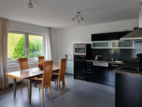 巴特梅根特海姆的住宿－Ferienwohnung Panoramablick，厨房配有木桌、椅子、桌子和桌子。