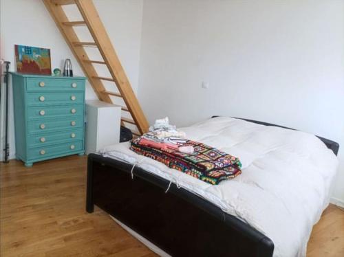 um quarto com uma cama com uma escada e uma cómoda em Jolie Maison proche métro em Romainville
