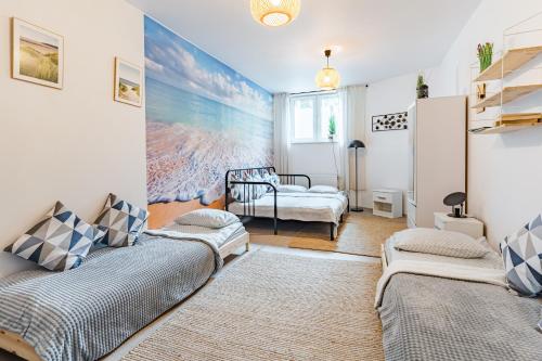 uma sala de estar com duas camas e um sofá em Sopot Pokoje Vitalis em Sopot