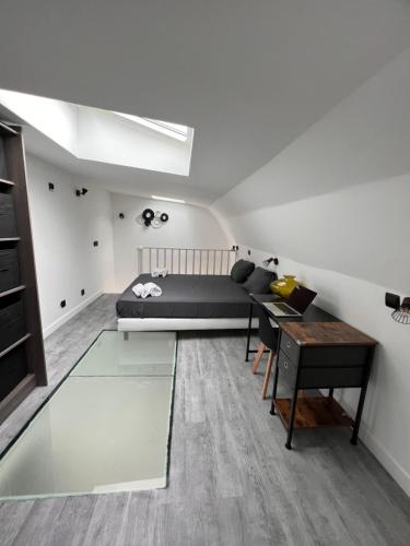 a living room with a bed and a desk at Joli duplex in Colombes