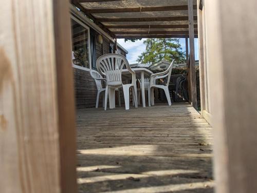a row of white chairs sitting on a porch at Mobil Home Confort 4 Places in Biesheim