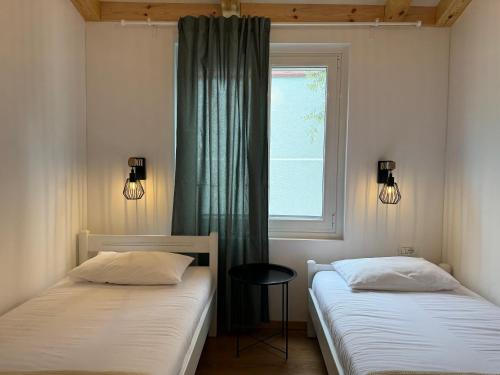2 camas en una habitación con ventana en Tonea's Houses, en Himare